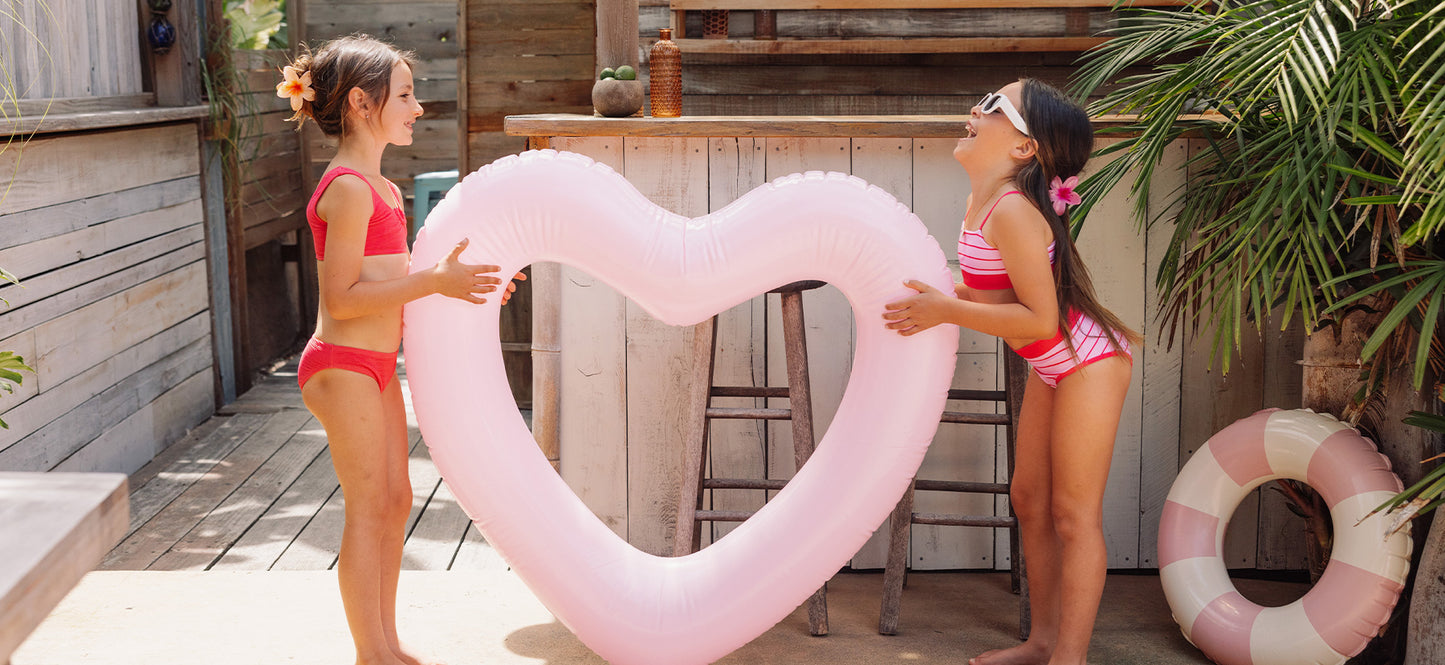 group of kids at the beach in red and pink swimwear
