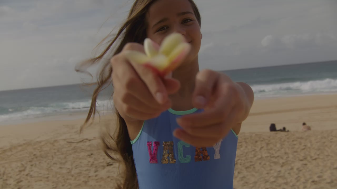 group of kids at the beach in red and pink swimwear